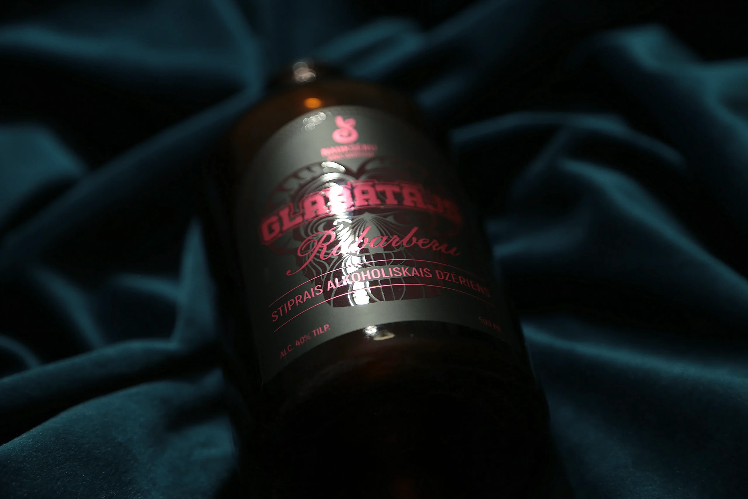 A dark bottle with a spot varnish label, where glossy varnish highlights design elements on a matte background.