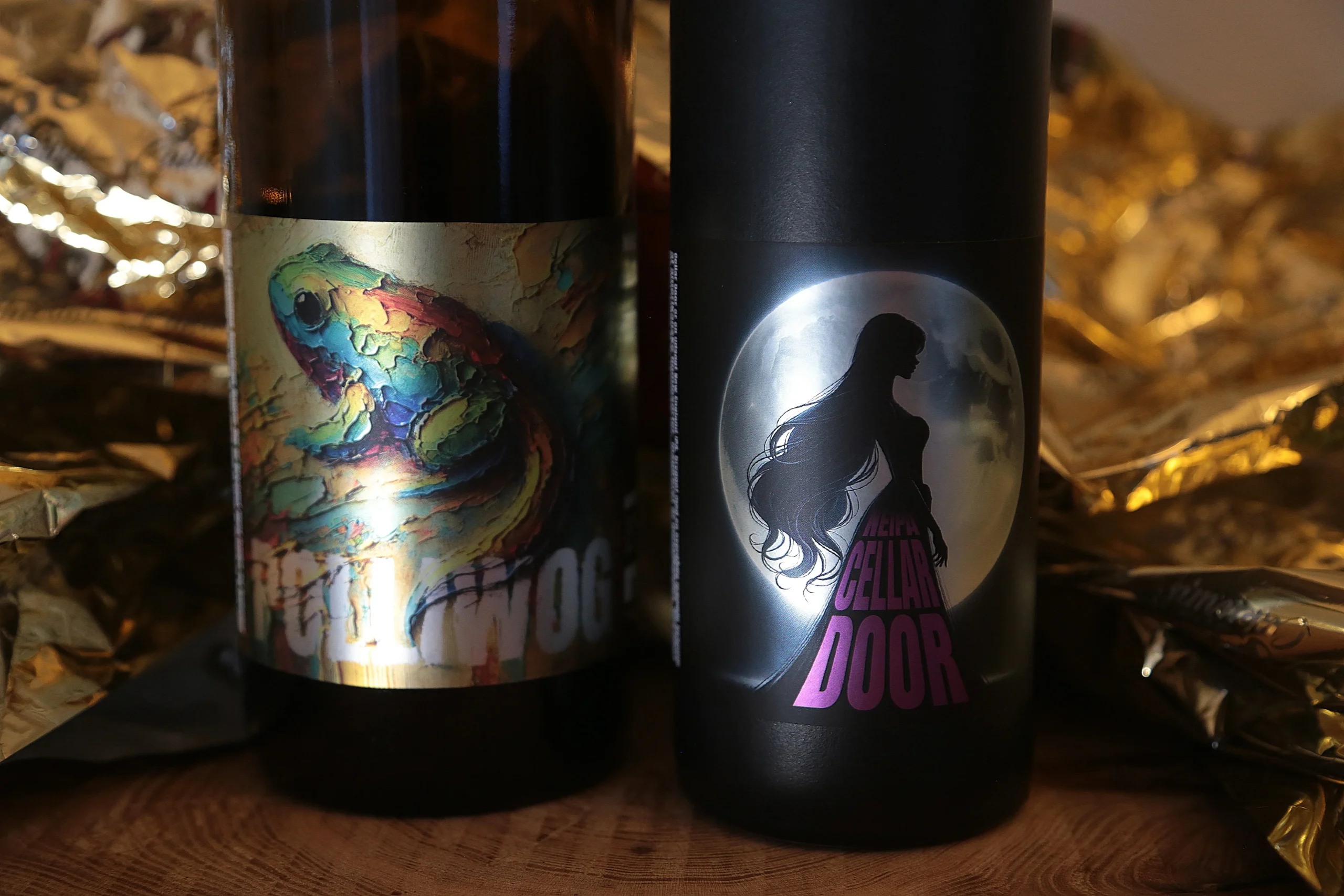 Two bottles with overlay labels - one with a holographic fish design and the other with a glossy silhouette decoration on a dark background.