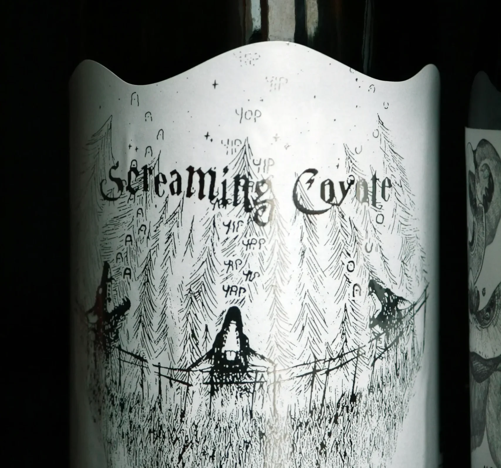 A bottle with a laser-cut label "Screaming Coyote", whose shape and details are highlighted with precise laser cutting.
